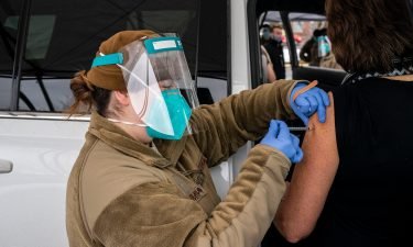 Washington National Guard medic Caityln Smith administers a COVID-19 vaccine to a patient at Town Toyota Center on January 26 in Wenatchee