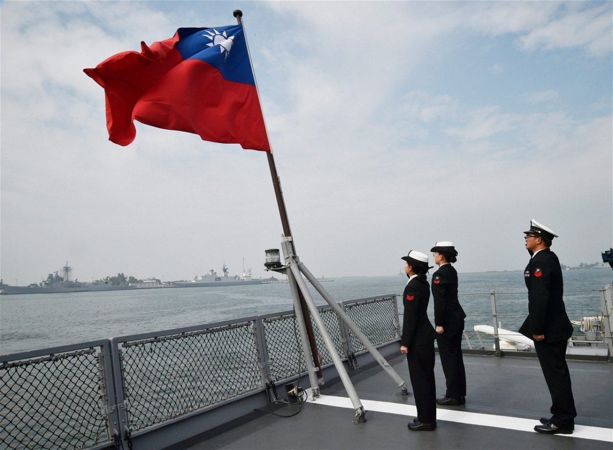 <i>MANDY CHENG/AFP/Getty Images</i><br/>Taiwanese sailors salute the island's flag on the deck of the Panshih supply ship after taking part in live fire drills