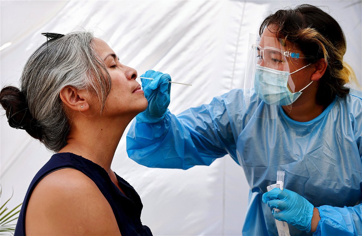 <i>Mario Tama/Getty Images</i><br/>A medical assistant administers a Covid-19 test to a person at Sameday Testing on July 14 in Los Angeles. Covid-19 cases are on the rise in most states as the highly transmissible Delta variant has become the dominant strain in the United States.