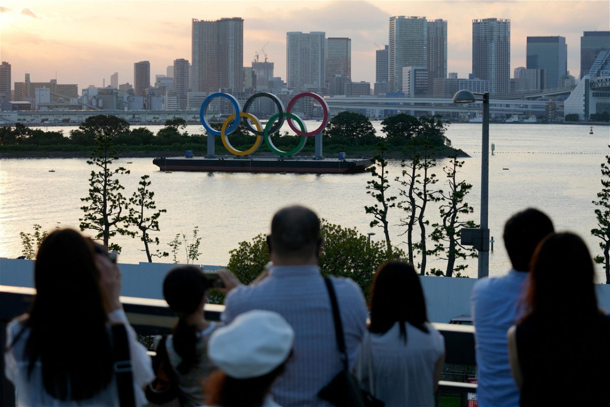 <i>Eugene Hoshiko/AP</i><br/>Visitors look at the Olympic rings floating in the water at Odaiba Marine Park