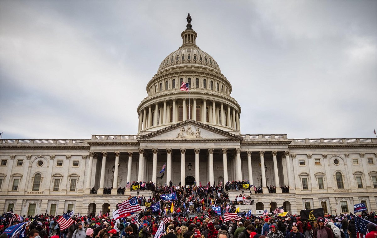 <i>Jon Cherry/Getty Images</i><br/>A large group of rioters stand on the East steps of the Capitol Building after storming its grounds on January 6