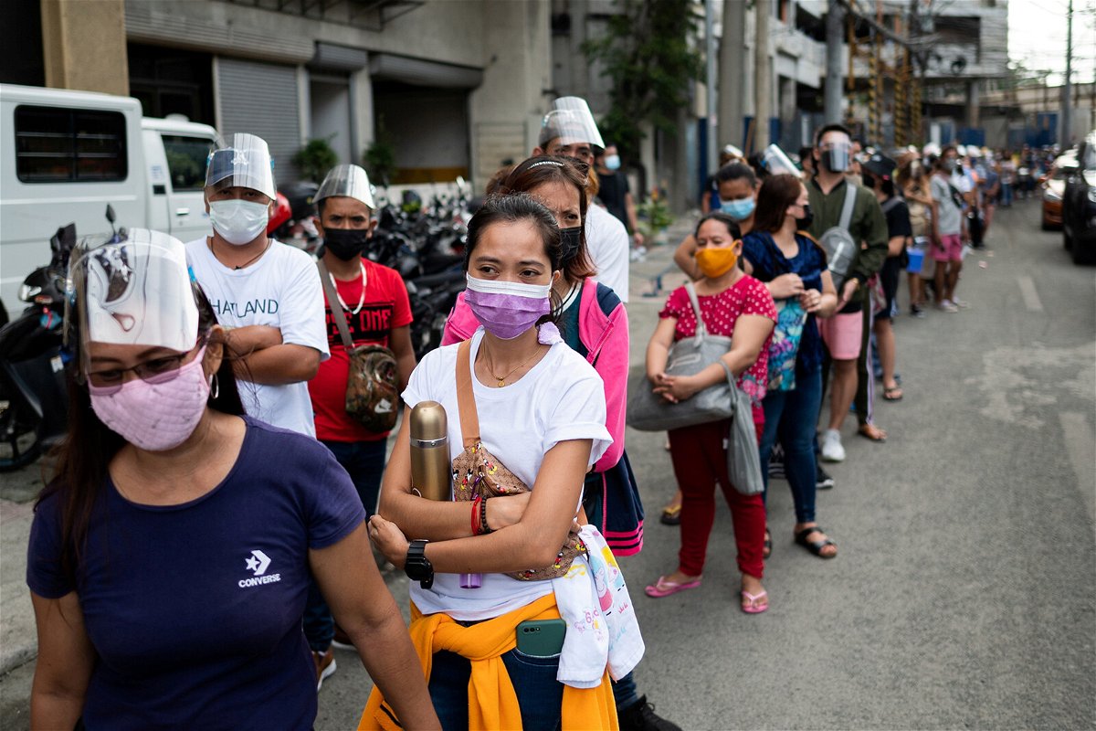 <i>Lisa Marie David/Reuters</i><br/>Filipinos waiting to be vaccinated against Covid-19 line up outside a mall in Manila on August 5.