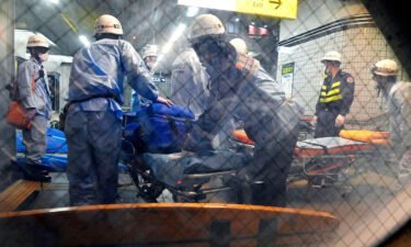 Emergency workers prepare stretchers at Soshigaya Okura Station in Tokyo after a stabbing on a commuter train on Aug. 6 left at least 10 people injured.