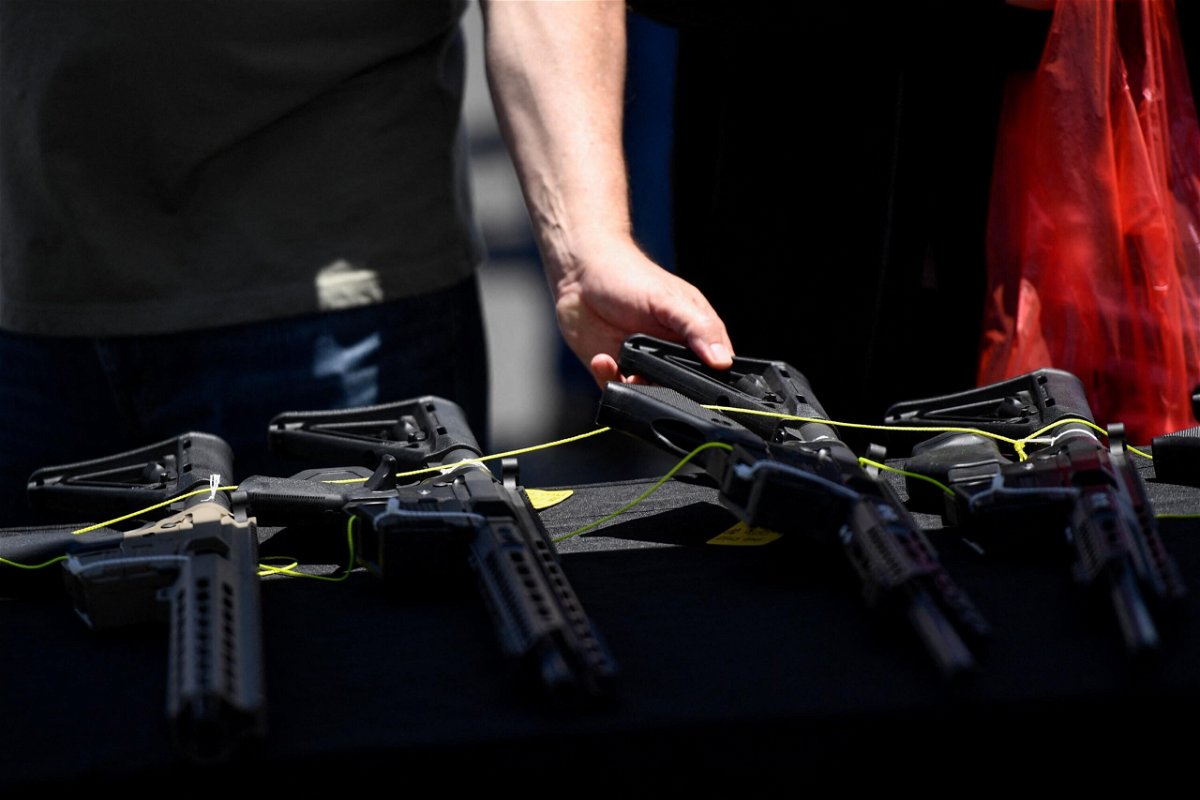 <i>PATRICK T. FALLON/AFP/Getty Images</i><br/>A customer examines a California-compliant AR-15 style rifle displayed for sale at a vendor booth at a gun show in Costa Mesa