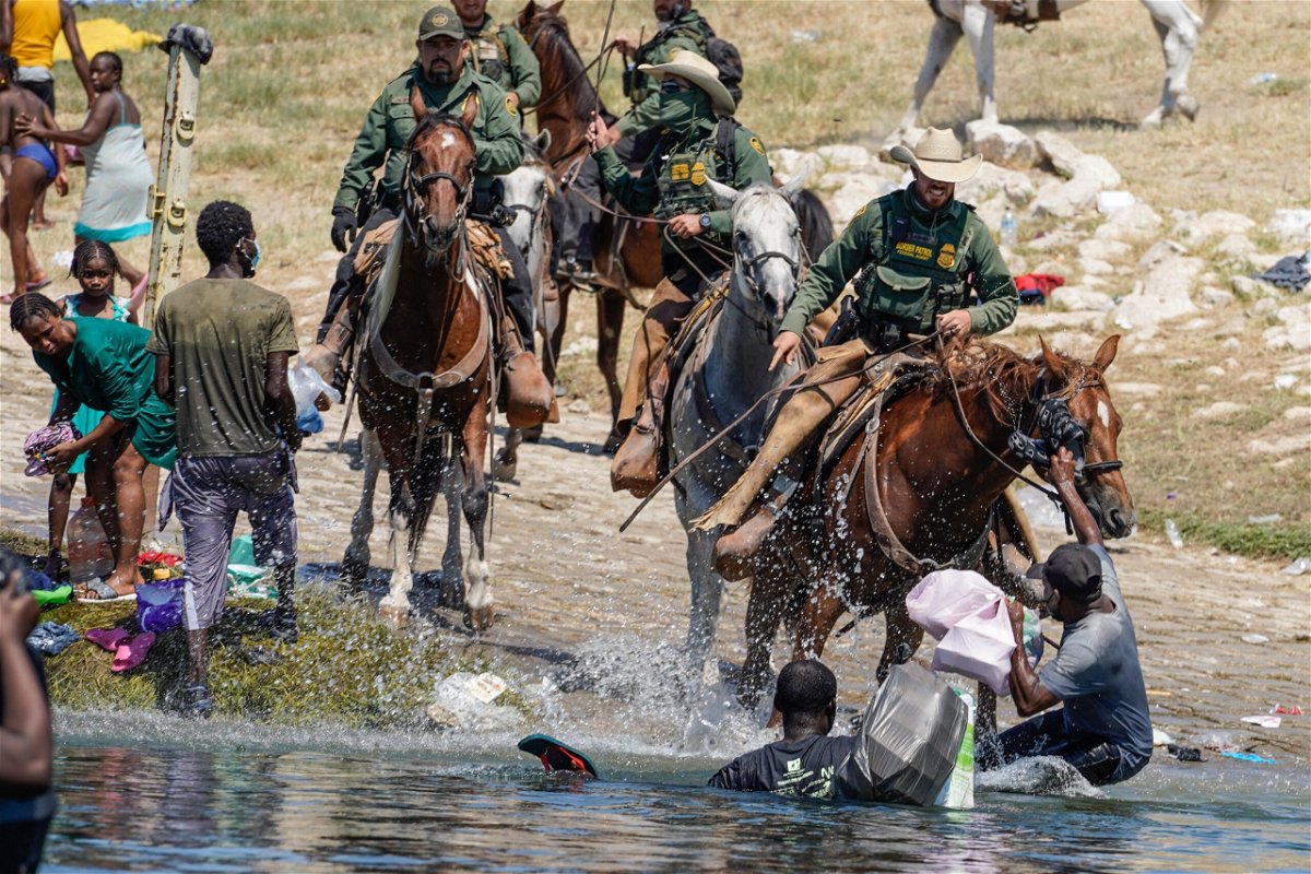 <i>Paul Ratje/AFP/Getty Images</i><br/>US Border Patrol agents on horseback try to stop Haitian migrants from entering an encampment on the banks of the Rio Grande near the Acuna Del Rio International Bridge in Del Rio