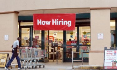A Now Hiring sign hangs near the entrance to a Winn-Dixie Supermarket on September 21 in Hallandale