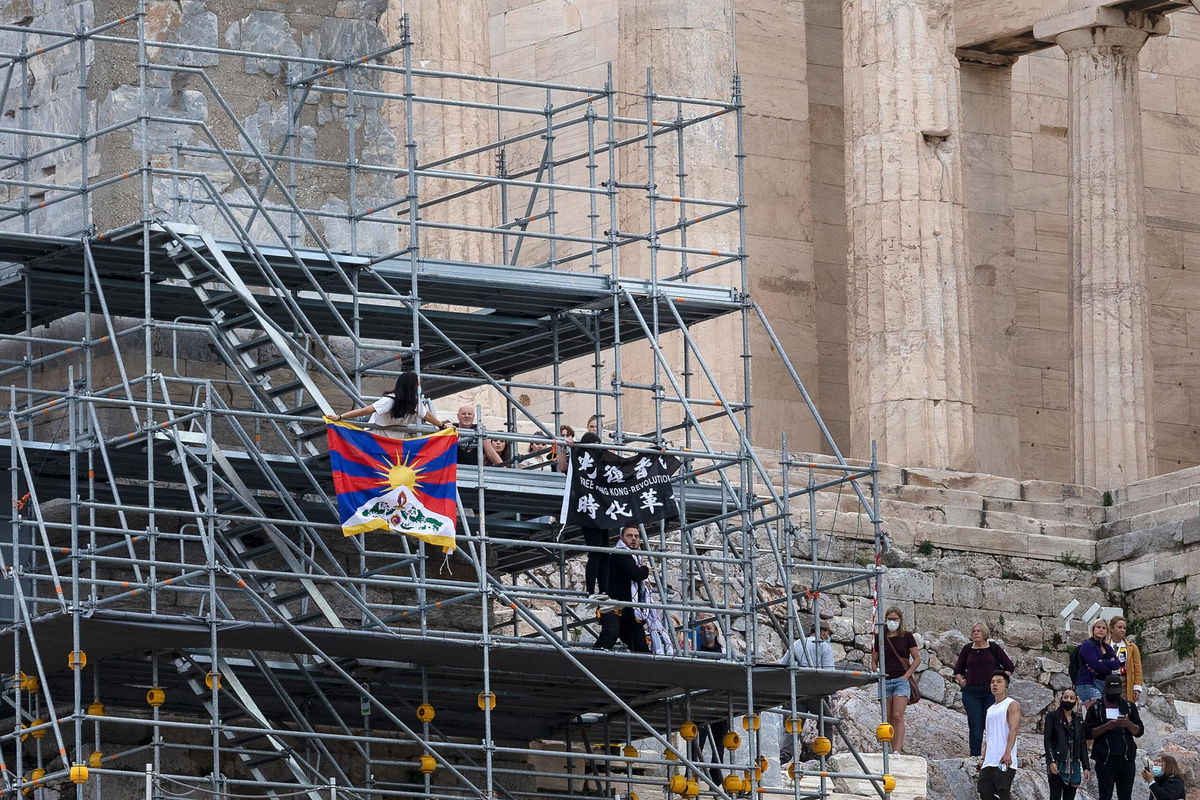 <i>Yorgos Karahalis/AP</i><br/>Protesters raise a Tibetan flag and a banner from scaffolding at the Acropolis hill