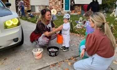 Crystal Conover (center) distributes glow sticks to children to help keep them safe at night while trick-or-treating.