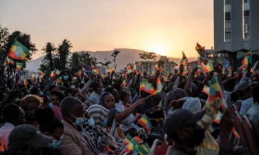A crowd wave Ethiopian flags during a memorial service for the victims of the Tigray conflict organized by the city administration
