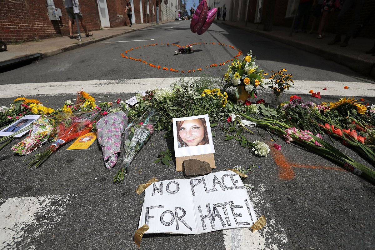 <i>Chip Somodevilla/Getty Images</i><br/>Flowers surround a photo of 32-year-old Heather Heyer