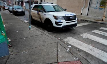 A Philadelphia police vehicle is seen parked next to chalk marks that identified spent bullet casings on Dec. 31.