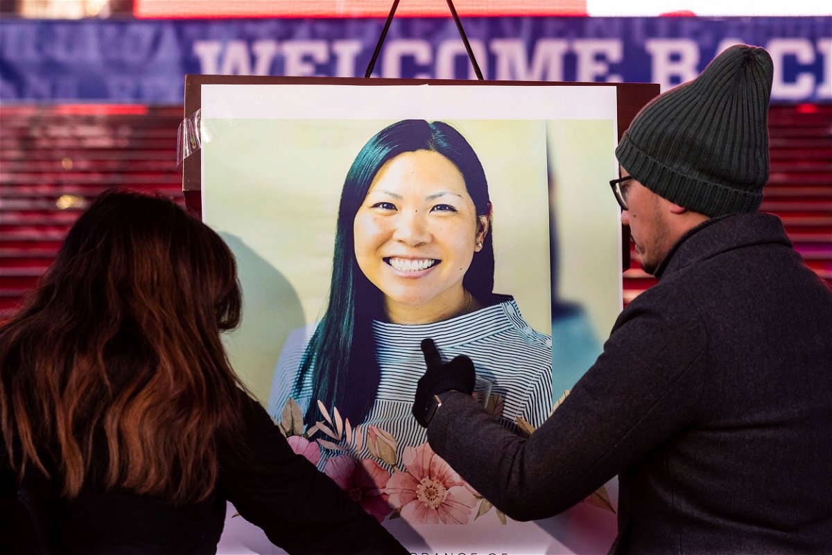 <i>Gabriele Holtermann/Sipa USA/AP</i><br/>Volunteers attach a photo of Michelle Alyssa Go to the podium before the candlight vigil in her honor in Times Square in New York