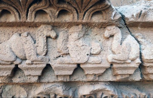 Artwork on a temple in northern Iraq depicts hybrid camels flanking a royal figure.