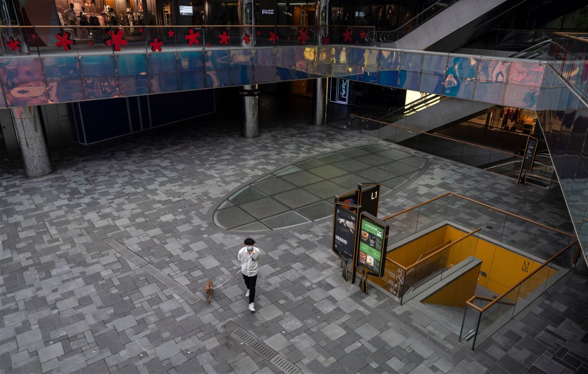 <i>Kevin Frayer/Getty Images</i><br/>A man walks his dog through Taikoo Li mall after many retail stores were closed to help prevent the spread of COVID-19 on May 10 in Beijing