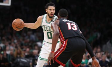 Jayson Tatum (left) looks to move the ball defended by Bam Adebayo.