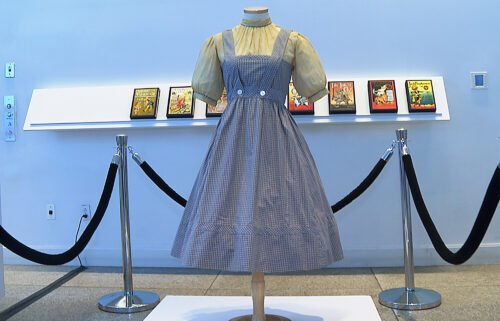 A judge blocks the $1.2 million 'Wizard of Oz' dress sale amid an ownership dispute.