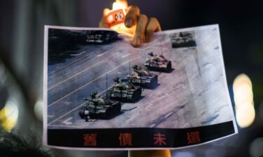 A man holds a poster of the famous 'Tank Man' who stood in front of Chinese military tanks at Tiananmen Square in Beijing in 1989.