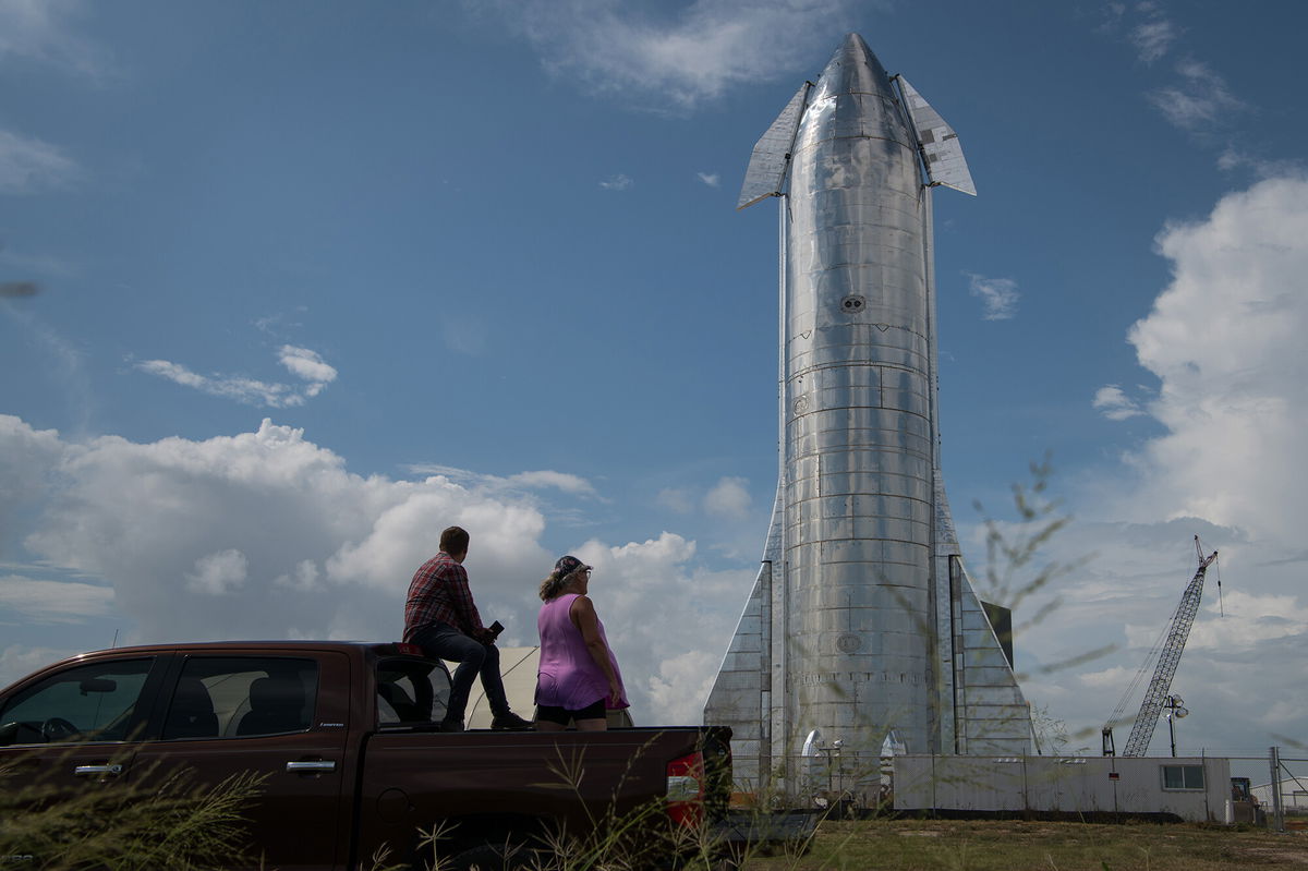 <i>Loren Elliott/Getty Images</i><br/>Space enthusiasts look at a prototype of SpaceX's Starship spacecraft at the company's Texas launch facility on September 28