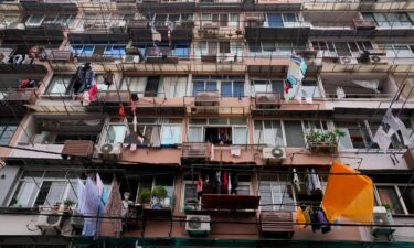 A resident wearing a mask looks out from his home in Shanghai on Thursday.