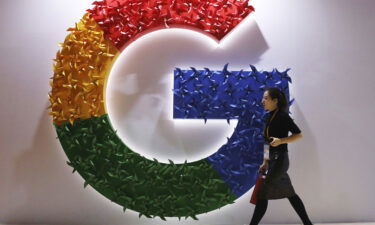 A woman walks past the logo for Google at the China International Import Expo in Shanghai