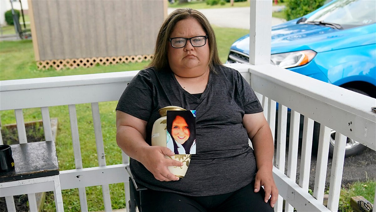 <i>Gene J. Puskar/AP</i><br/>Kelly Titchenell holds a photo of her mother Diania Kronk