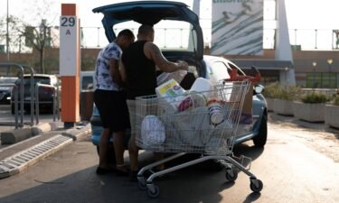 Customers load shopping into their vehicle in the parking lot of the Carrefour SA hypermarket in the Grand Littoral retail park in Marseille