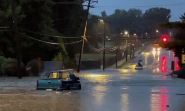 Floodwaters surround a truck on a street in the St. Louis area on Tuesday morning.