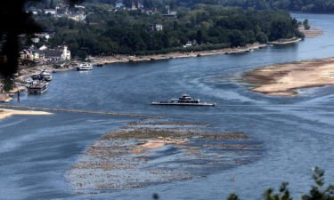 A ferry cruises past the partially dried riverbed of the Rhine river in Bingen