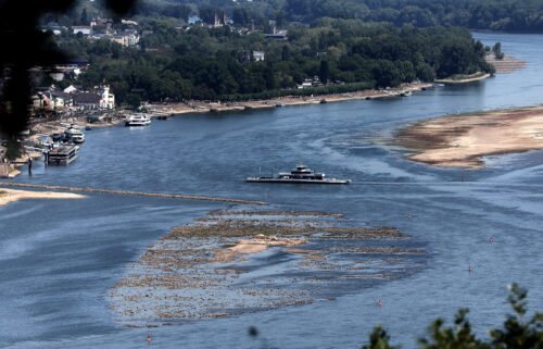 A ferry cruises past the partially dried riverbed of the Rhine river in Bingen