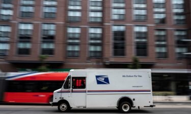 A postman drives a United States Postal service (USPS) mail delivery truck through Washington