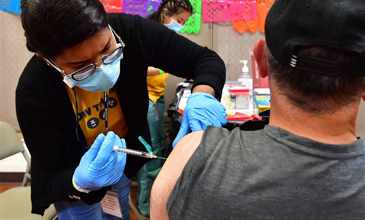 <i>Frederic J. Brown/AFP/Getty Images</i><br/>Registered Nurse Mariam Salaam administers the Pfizer booster shot at a Covid vaccination and testing site in Los Angeles on May 5. The Biden administration will stop buying Covid-19 vaccines
