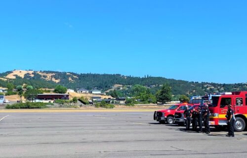 A medical helicopter carrying the firefighter's body arrives at the Roseburg Regional Airport in Oregon.