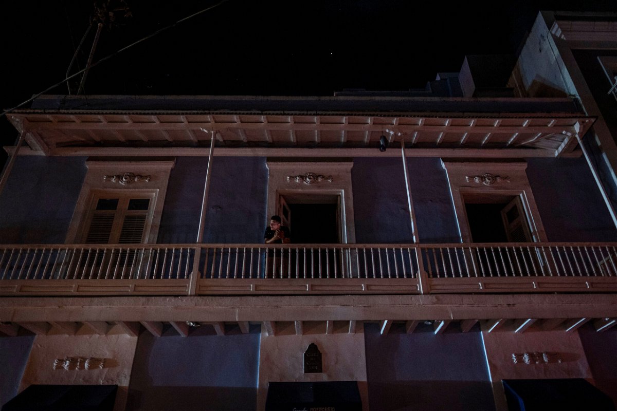 <i>Ricardo Arduengo/AFP/Getty Images</i><br/>A man stands on a balcony in San Juan after a major power outage on April 6.