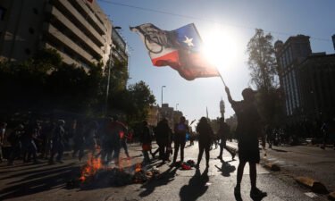 A demonstrator waves the Chilean flag during a November 2020 protest against then President Sebastian Pinera in Santiago.
