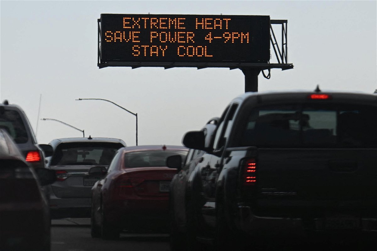 <i>Patrick T. Fallon/AFP/Getty Images</i><br/>Vehicles drive past a sign on the 110 Freeway warning of extreme heat and urging energy conservation during a heat wave in downtown Los Angeles