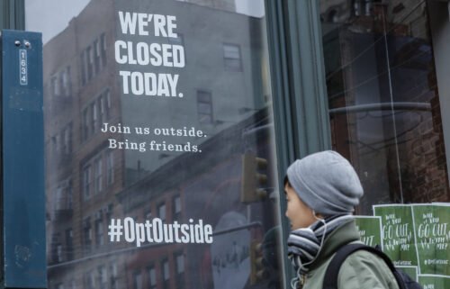 A woman walks past a closed REI store in New York on Black Friday