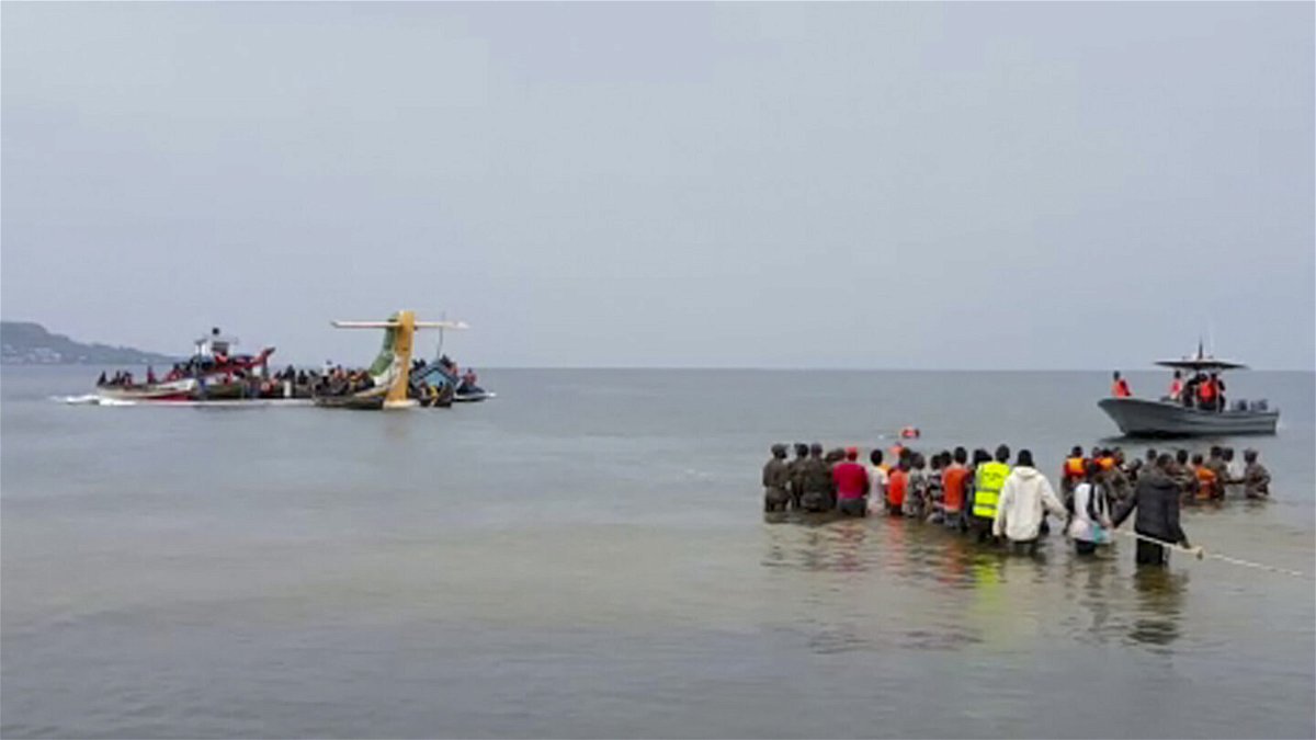 <i>AP</i><br/>Rescuers in boats and standing in the water are seen around the tail fin of a crashed Precision Air passenger aircraft on the shores of Lake Victoria in Bukoba