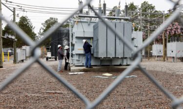 Duke Energy workers inspect a transformer radiator that they said was damaged by gunfire in Carthage