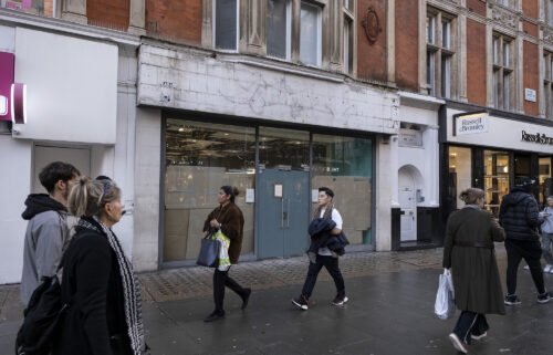 Shoppers pass a closed down retail shop space on Oxford Street in London