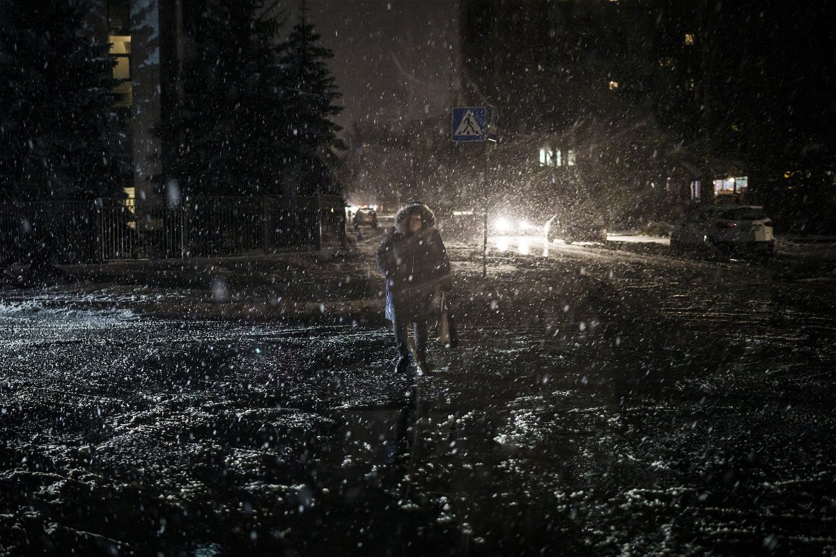 <i>Felipe Dana/AP</i><br/>A woman crosses the street during snowfall