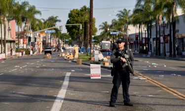 A Monterey Park police officer stands guard near where vendor tents once stood for the Lunar New Year festival near the Star Dance Studio in Monterey Park