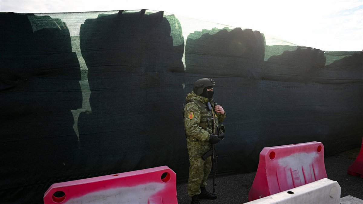 <i>Natalia Kolesnikova/AFP/Getty Images</i><br/>A Belarusian border guard keeps watch and stands by a barricade made of truck tyres at the Divin border crossing point between Belarus and Ukraine in the Brest region on February 15.