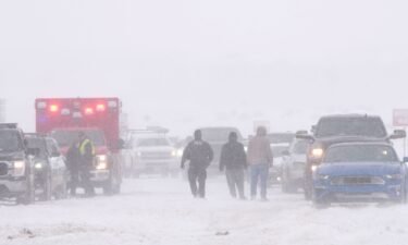 Police and emergency workers try to free vehicles from the snow on Mountain View Parkway in Lehi