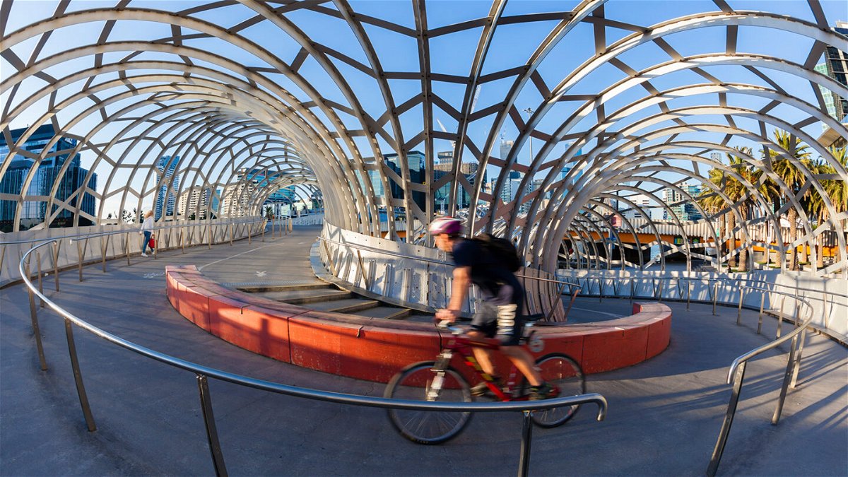 <i>ymgerman/iStock Editorial/Getty Images</i><br/>A cyclist rides on the Webb Bridge in Docklands
