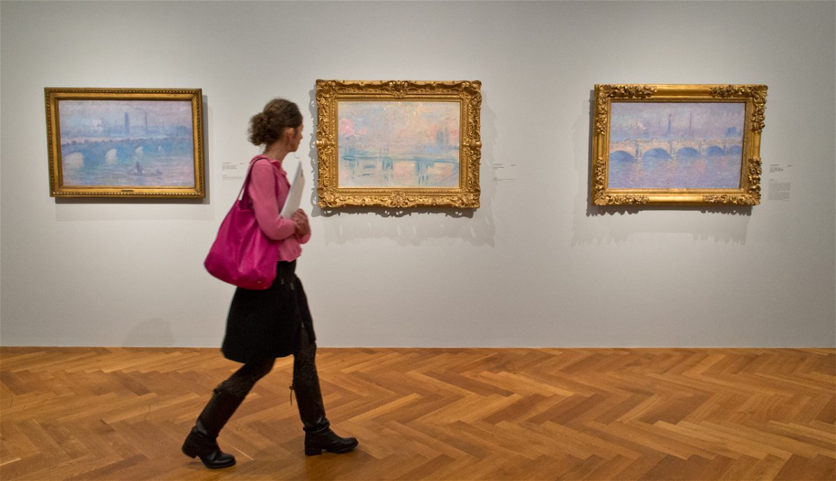 <i>Boris Roessler/picture alliance/Getty Images/FILE</i><br/>A woman walks through a Claude Monet exhibition at the Stadel Museum in Frankfurt