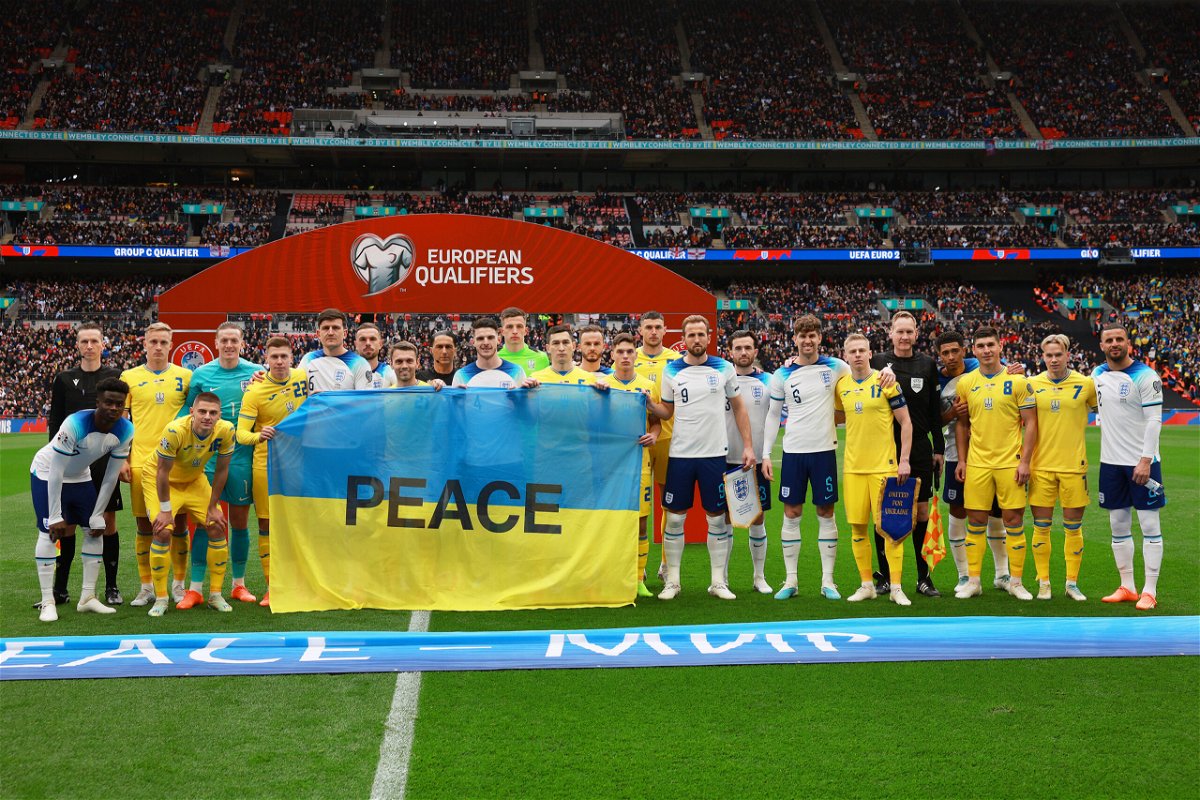 <i>Eddie Keogh/The FA/Getty Images</i><br/>Players from both side's pose for a photograph with a Ukraine flag with the word Peace on prior to the Euro 2024 qualifying match on March 26