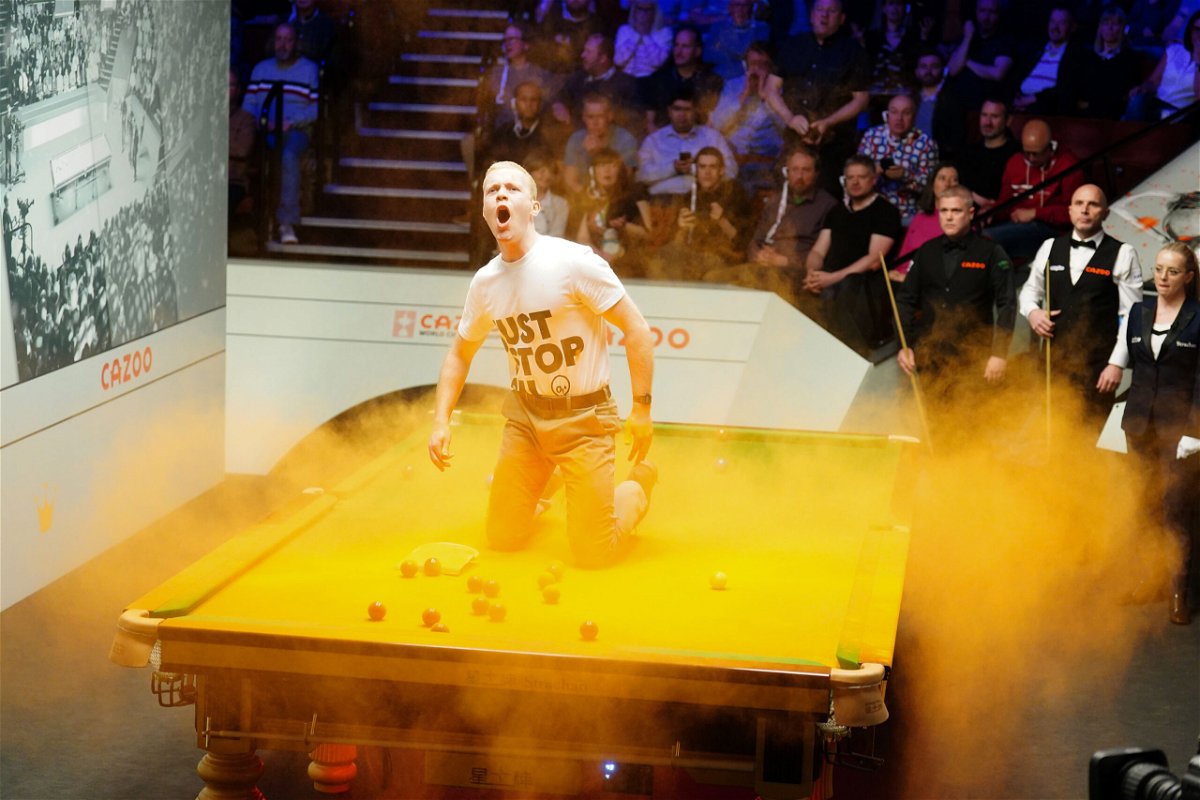 Just Stop Oil protester disrupts World Snooker Championship by throwing orange powder paint on table