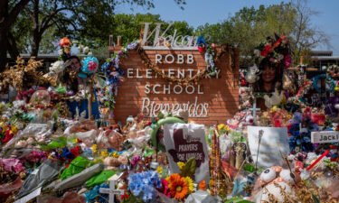 The Robb Elementary School sign is covered in flowers and gifts on June 17 in Uvalde