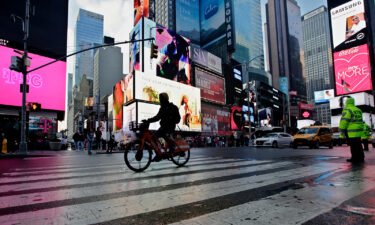 A man rides an e-bike through Times Square on February 21