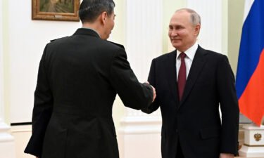 Russian President Vladimir Putin and Chinese Defense Minister Gen. Li Shangfu shake hands during their meeting at the Kremlin in Moscow